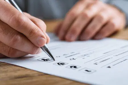 Ruka ispunjava obrazac s ikonama kao primjer za kako ispuniti zahtjev za dječji doplatak