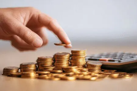 Ruka odvaja mali dio hrpe novca nakon izračuna metafora za kako izračunati porez na dobit