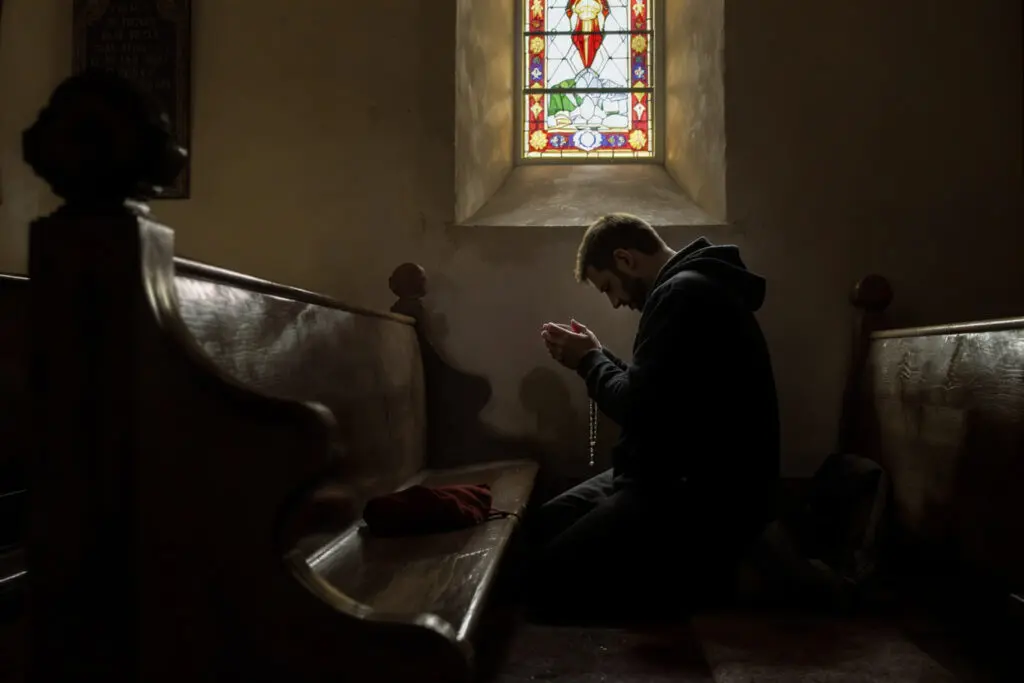 osoba u crkvi koja pokazuje kako se moli krunica u tišini i sabranosti