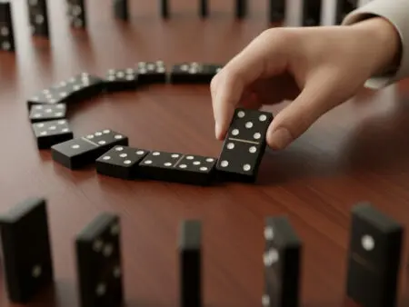 ruka koja polaže domino pločicu na stol kako bi nastavila niz što prikazuje pravila igre domino