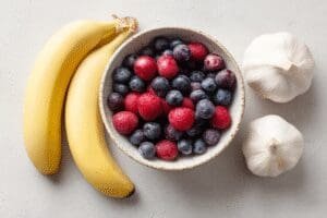 Prikaz namirnica koje pomažu u snižavanju krvnog tlaka banana bobičasto voće i češnjak