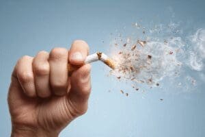 Ruka odlučno lomi cigaretu simbolizirajući trajnu odluku o prestanku pušenja
